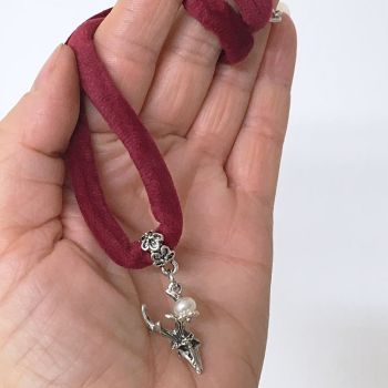 Kette aus dunkelroter Samtkordel mit Hirschkopf und Süßwasserperle Detail