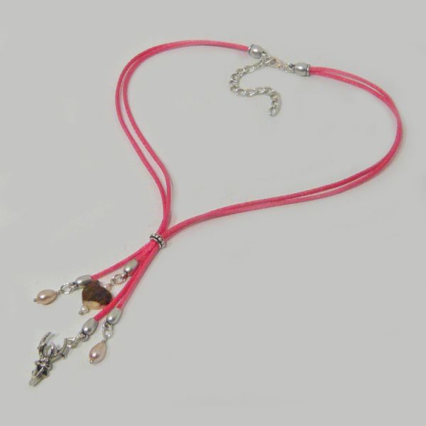 Y-Kette aus rosa Satinkordeln Hirschhornherz Hirschkopf und Süßwasserperlen liegend